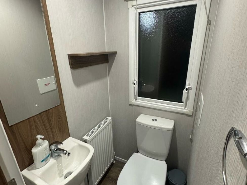 a bathroom with a sink, toilet, and window at Butlins Skegness - Holiday Accommodation 21028 in Skegness
