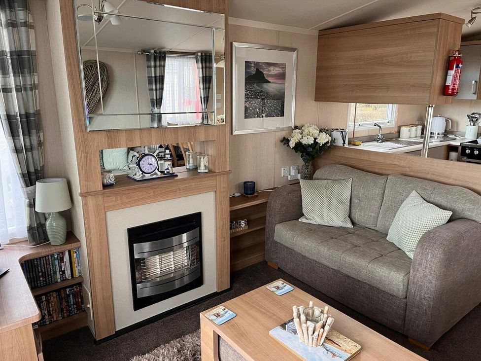 a living room with a fireplace, sofa, and shelves at Eastgate Caravan Park - Holiday Accommodation 21087 in Ingoldmells