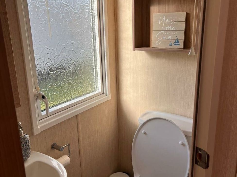 a small bathroom with a toilet and sink at Eastgate Caravan Park - Holiday Accommodation 21087 in Ingoldmells