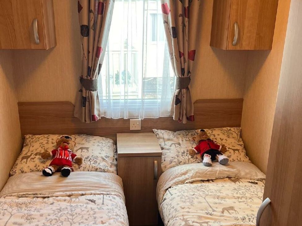 a bedroom with two single beds, each with stuffed animals, at Eastgate Caravan Park - Holiday Accommodation 21087 in Ingoldmells