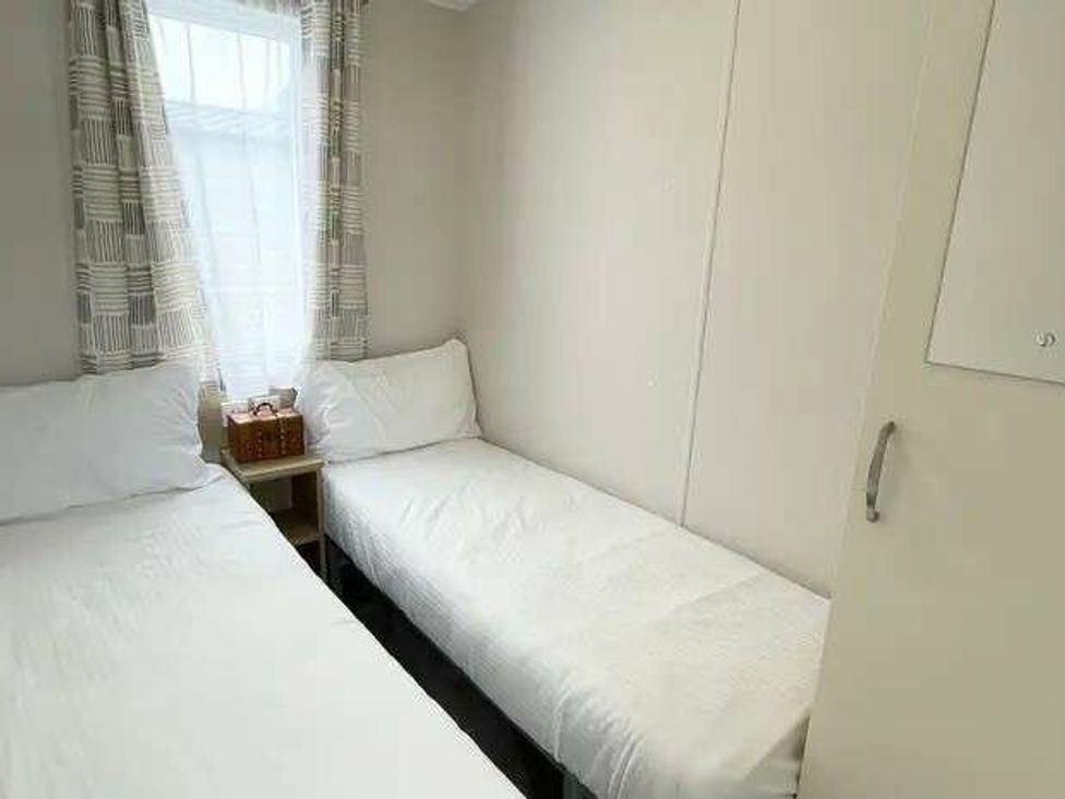 a bedroom with two single beds and a window at Trevella Park - Holiday Accommodation 21105 in Crantock