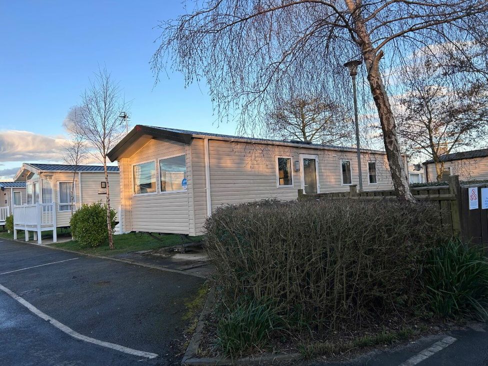 a mobile home with a pathway and shrubs at Cala Gran Holiday Park - Holiday Accommodation 21106 in Fleetwood