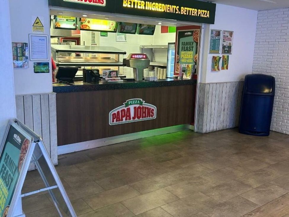 a restaurant counter with a Papa John's sign and menu at Cala Gran Holiday Park - Holiday Accommodation 21106, Fleetwood