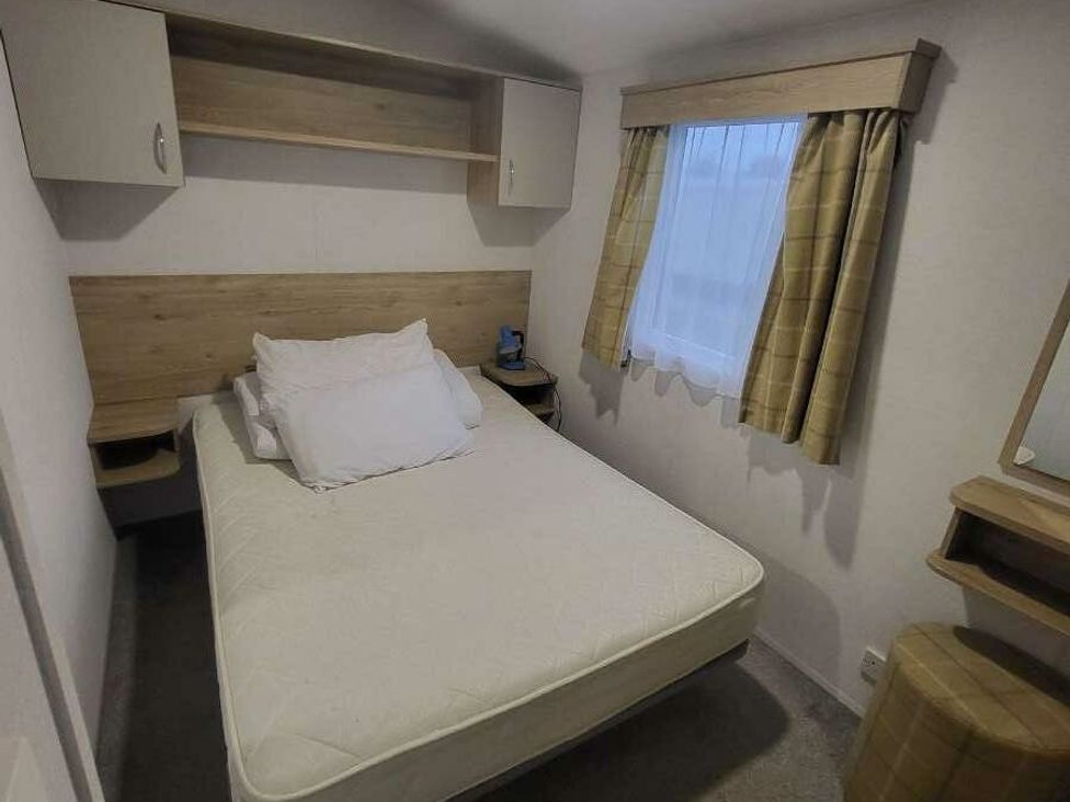 a bedroom with a bed, shelves, and a window at Ty Mawr Holiday Park - Holiday Accommodation 21121 in Ty Mawr