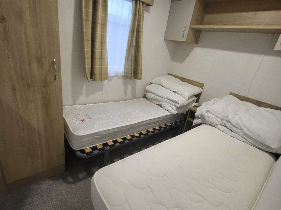 a bedroom with two single beds and a wardrobe at Ty Mawr Holiday Park - Holiday Accommodation 21121 Ty Mawr