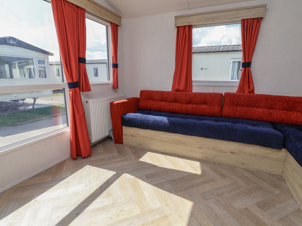A living room with a sofa and a window at Ty Mawr Holiday Park - Holiday Accommodation 21121, Ty Mawr