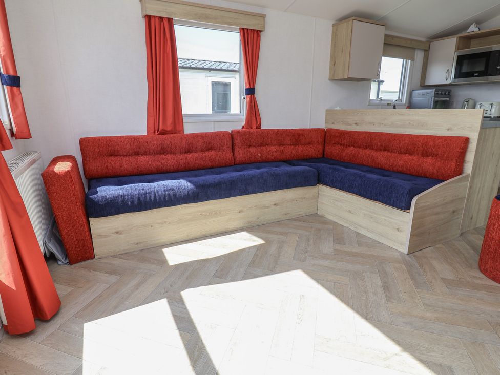 A living room with a sofa and windows at Ty Mawr Holiday Park - Holiday Accommodation 21121 Ty Mawr