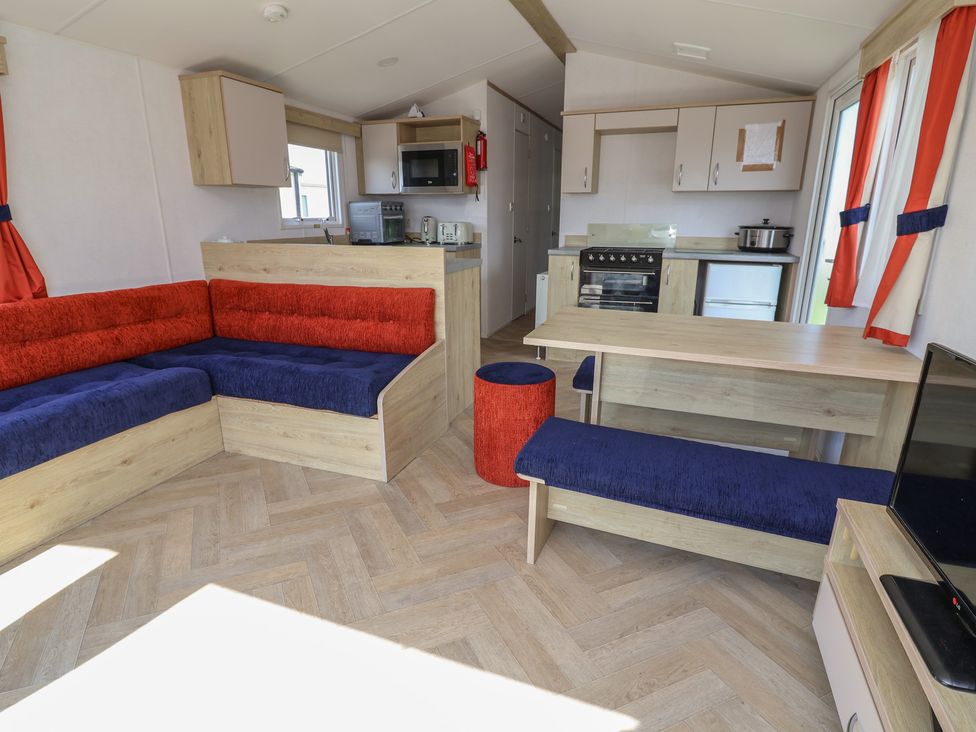 A living room with a sofa and dining area at Ty Mawr Holiday Park - Holiday Accommodation 21121 Ty Mawr