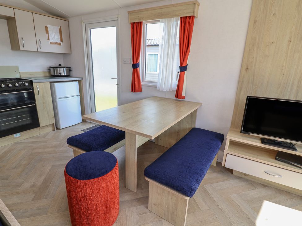 A dining area with a table and seating in Ty Mawr Holiday Park - Holiday Accommodation 21121 Ty Mawr