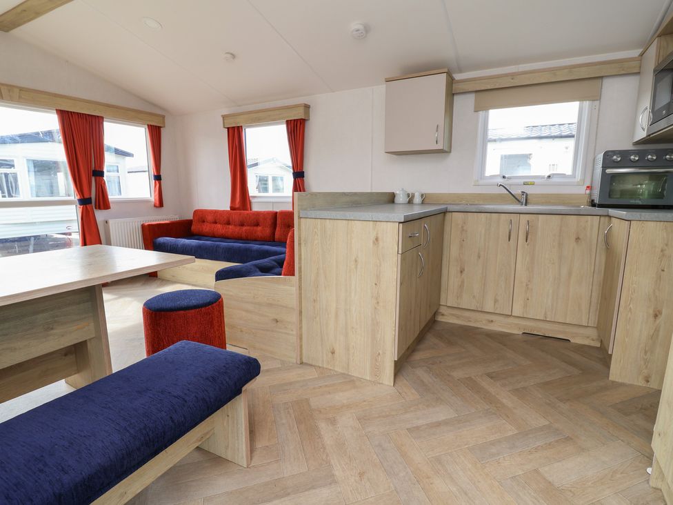 A kitchen with a dining area and seating arrangements at Ty Mawr Holiday Park - Holiday Accommodation 21121 Ty Mawr