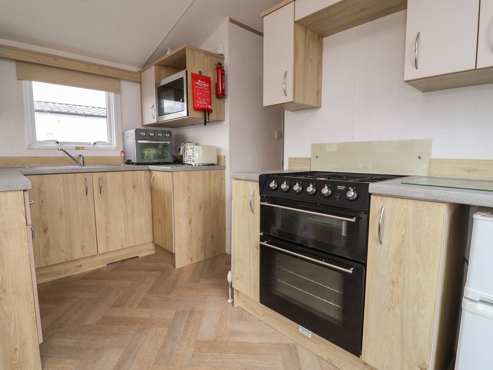A kitchen with an oven and microwave at Ty Mawr Holiday Park - Holiday Accommodation 21121, Ty Mawr