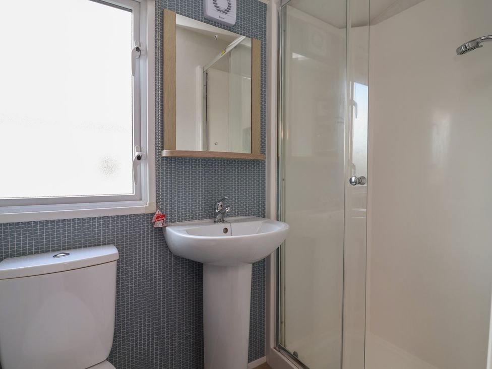 A bathroom with a toilet, sink, and shower at Ty Mawr Holiday Park - Holiday Accommodation 21121 in Ty Mawr