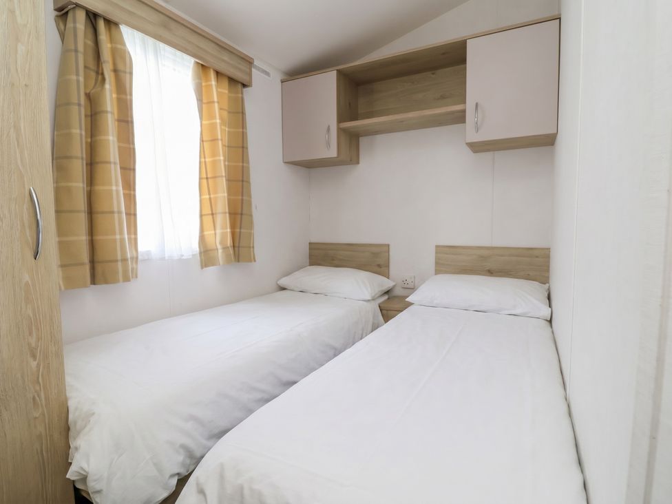 A bedroom with two single beds and a window at Ty Mawr Holiday Park - Holiday Accommodation 21121, Ty Mawr