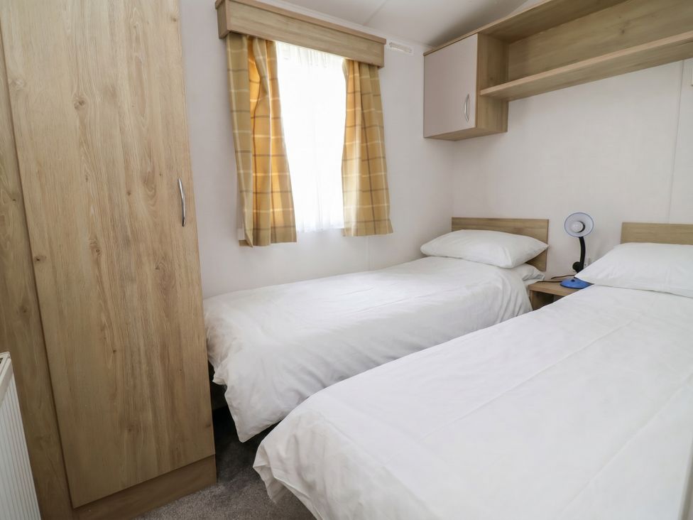 A bedroom with two single beds and a wardrobe at Ty Mawr Holiday Park - Holiday Accommodation 21121, Ty Mawr