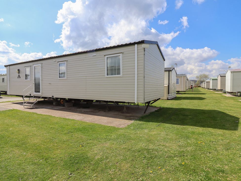 A static caravan and green lawn at Ty Mawr Holiday Park - Holiday Accommodation 21121 Ty Mawr