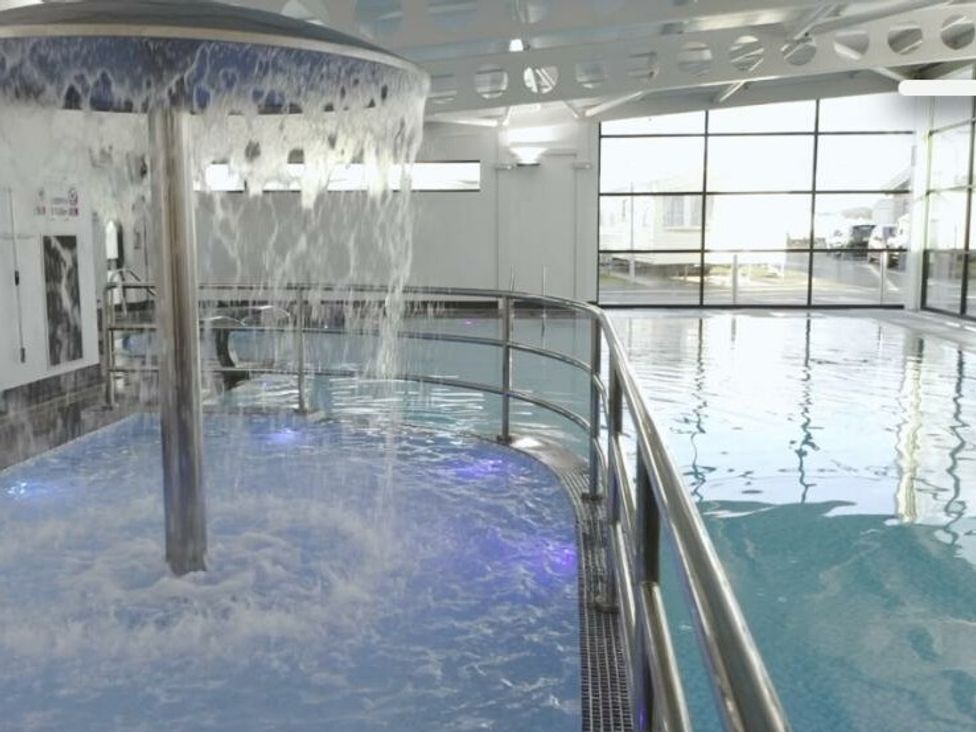 a swimming pool area with a fountain feature at Whitehouse Leisure Park - Holiday Accommodation 21355 Towyn