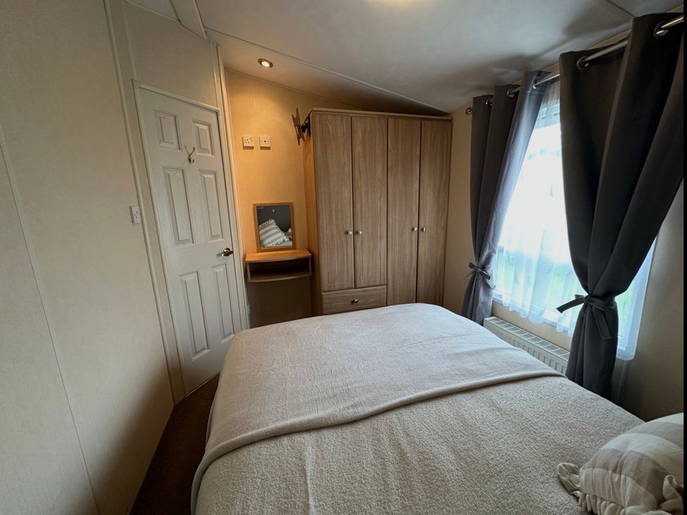 A bedroom with a bed and wardrobe at Whitehouse Leisure Park - Holiday Accommodation 21355 Towyn