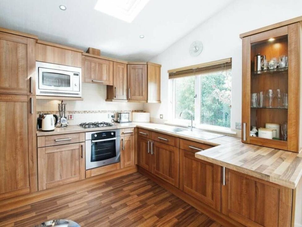 a kitchen with wooden cabinetry and a window at St Minver Holiday Park - Holiday Accommodation 21443 in Wadebridge