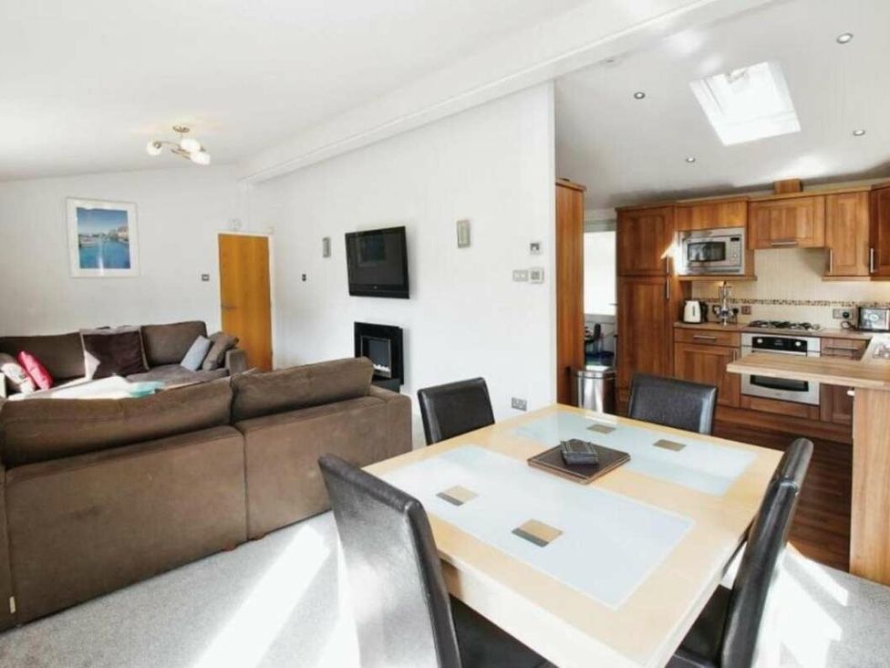 a living room and kitchen area with a dining table at St Minver Holiday Park - Holiday Accommodation 21443 in Wadebridge