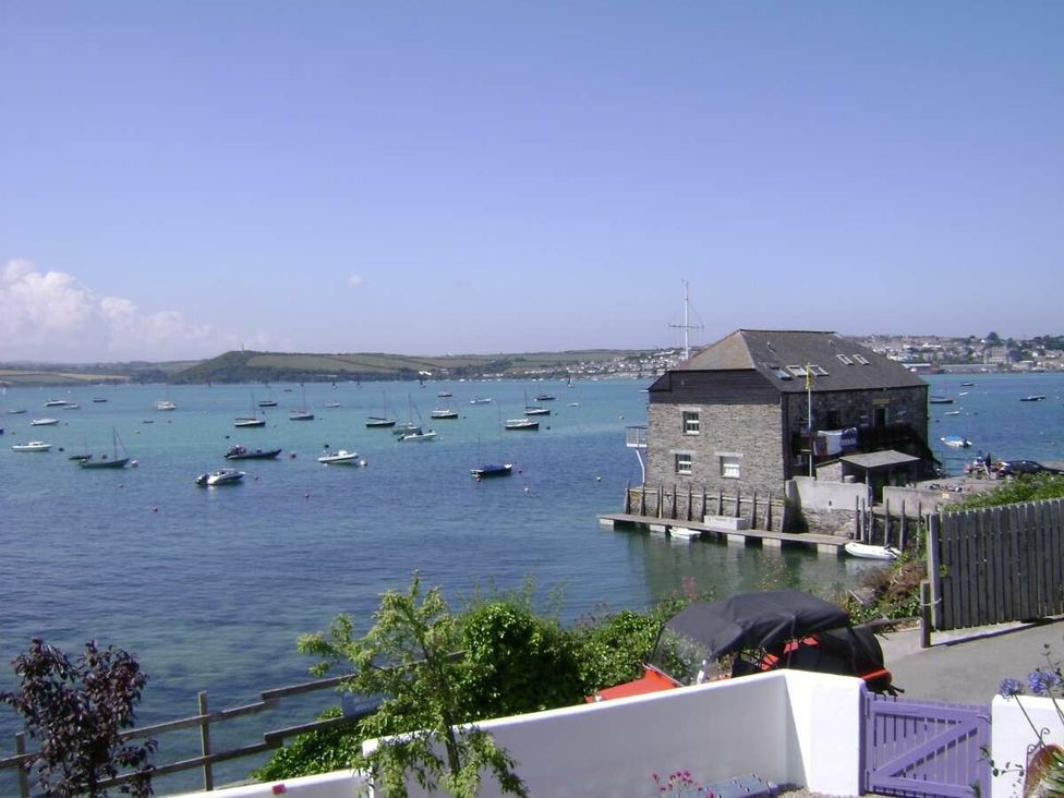 a view of a waterfront with boats and a stone building at St Minver Holiday Park - Holiday Accommodation 21443 in Wadebridge