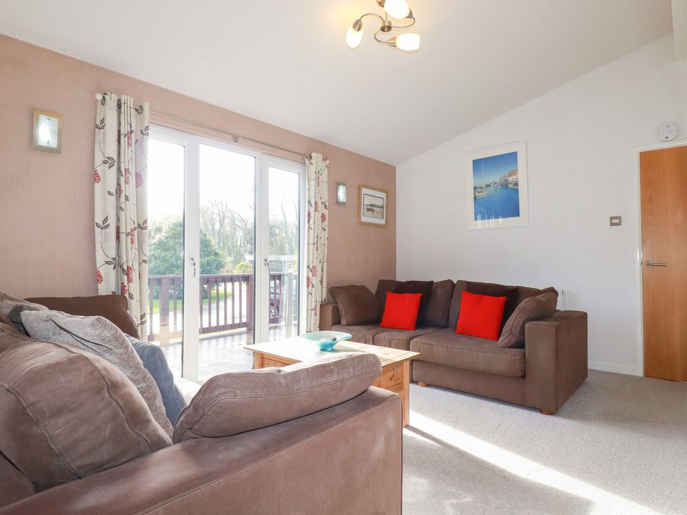 A living room with sofas and sliding doors at St Minver Holiday Park - Holiday Accommodation 21443 Wadebridge