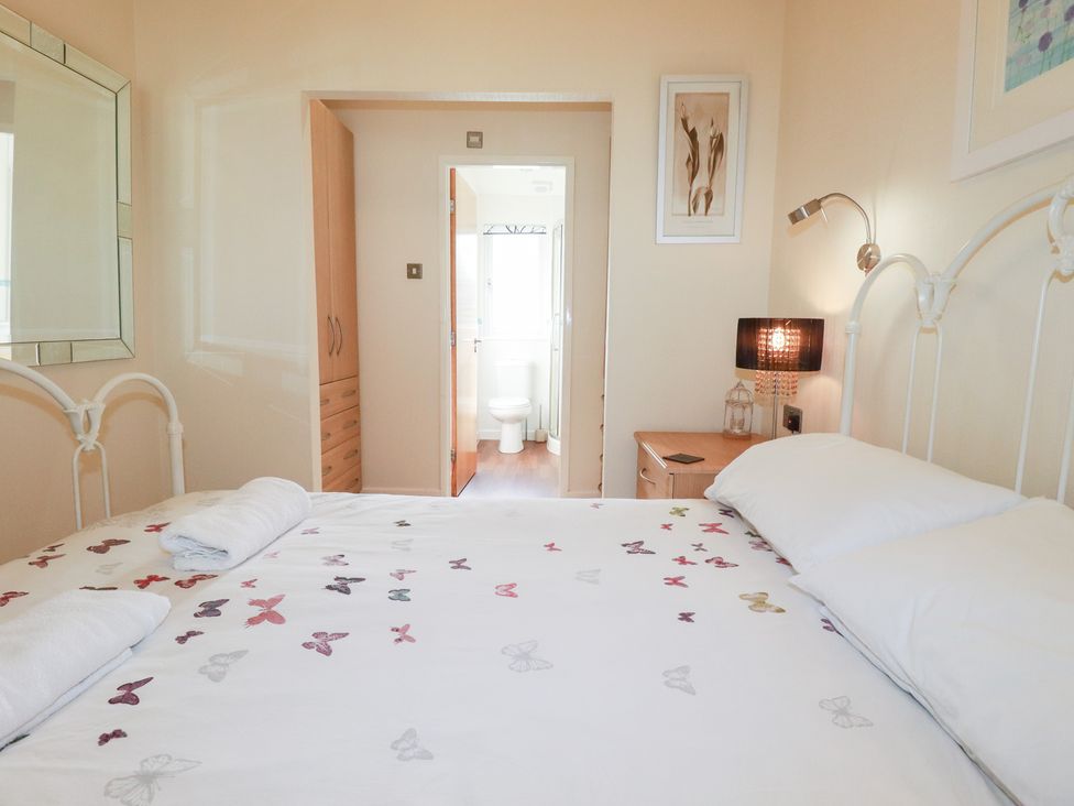 A bedroom with a bed and door to bathroom at St Minver Holiday Park - Holiday Accommodation 21443, Wadebridge
