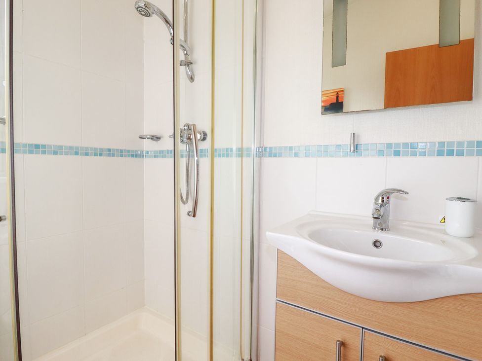 A bathroom with a shower, sink, and mirror at St Minver Holiday Park - Holiday Accommodation 21443 Wadebridge