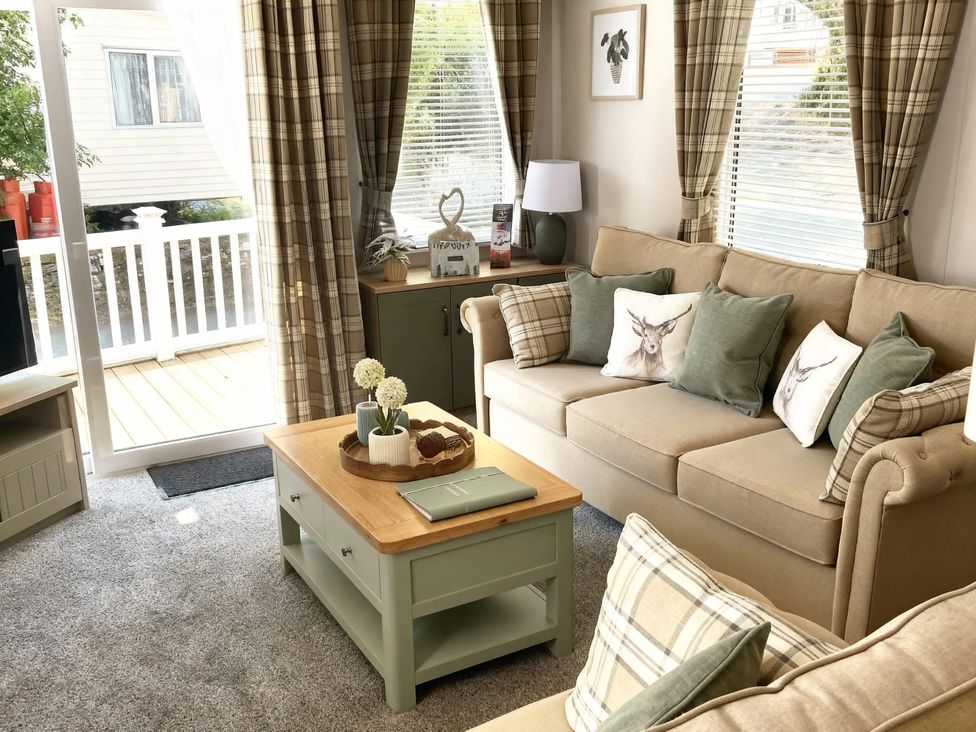 A living room with a sofa and coffee table at Aberdunant Hall Holiday Park - Holiday Accommodation 21962 Prenteg
