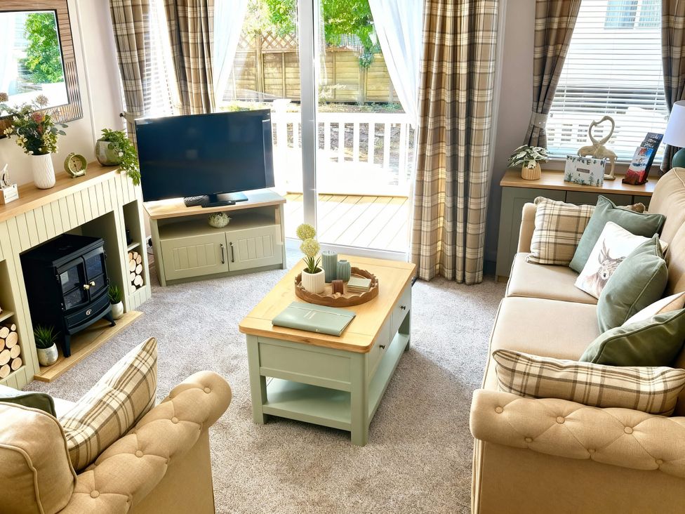 A living room with a television and sofa at Aberdunant Hall Holiday Park - Holiday Accommodation 21962 in Prenteg