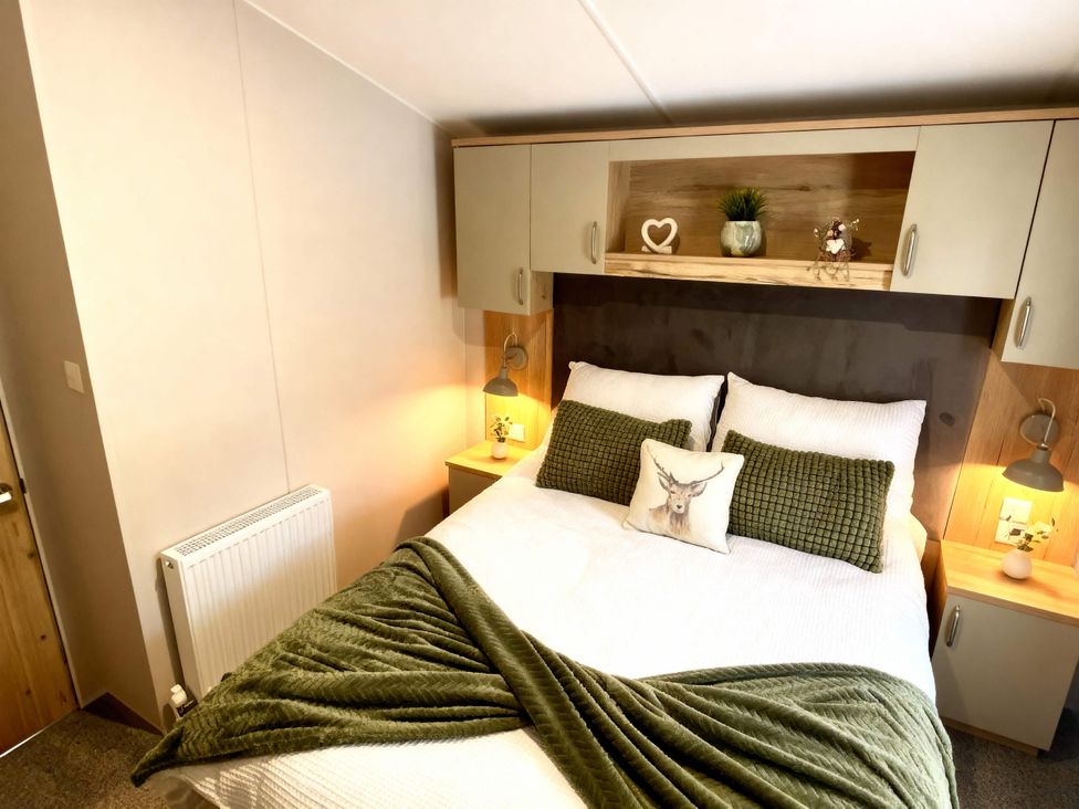 A bedroom with a bed and shelves at Aberdunant Hall Holiday Park - Holiday Accommodation 21962 in Prenteg