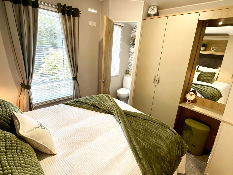 A bedroom with bed and wardrobe at Aberdunant Hall Holiday Park - Holiday Accommodation 21962 Prenteg