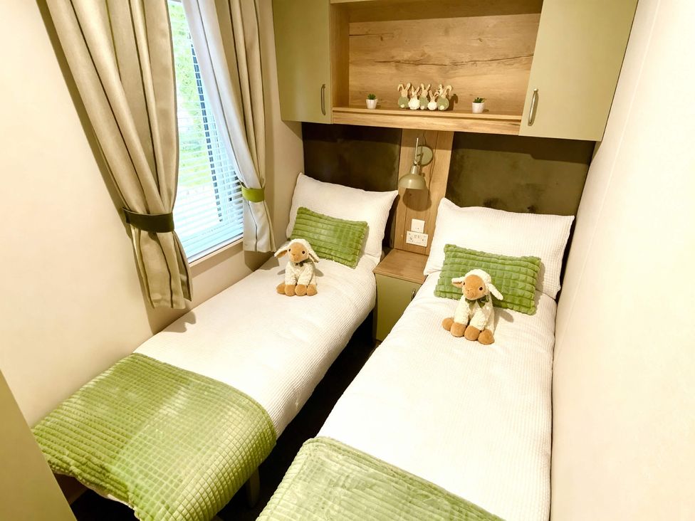 A bedroom with two beds and plush toys at Aberdunant Hall Holiday Park - Holiday Accommodation 21962, Prenteg