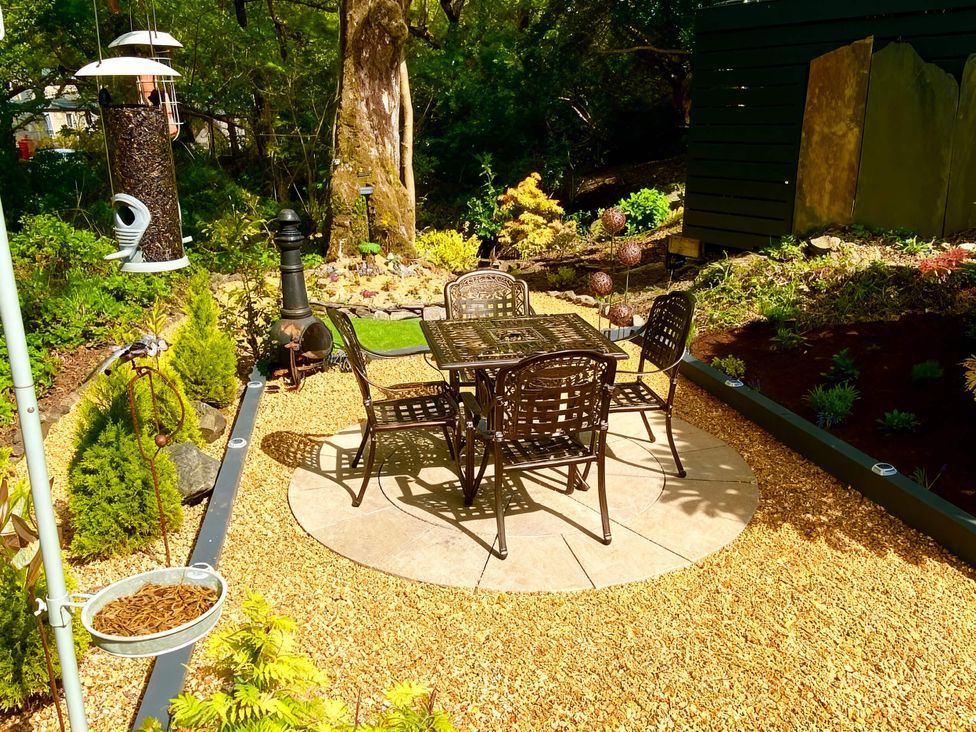 A garden with a table and chairs at Aberdunant Hall Holiday Park - Holiday Accommodation 21962, Prenteg