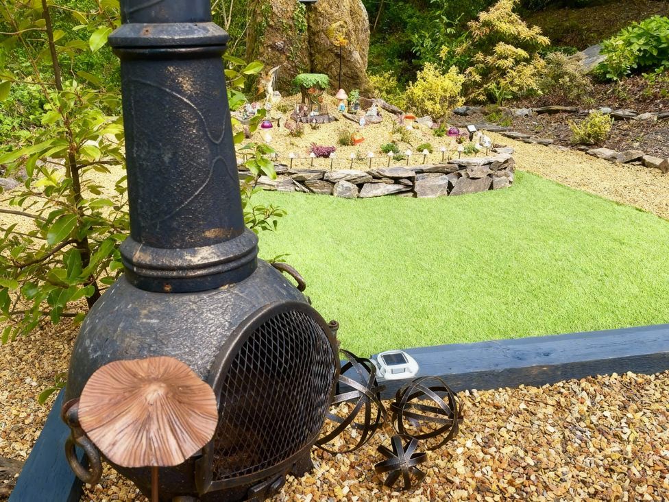 A garden featuring a chiminea and decorative elements at Aberdunant Hall Holiday Park - Holiday Accommodation 21962, Prenteg