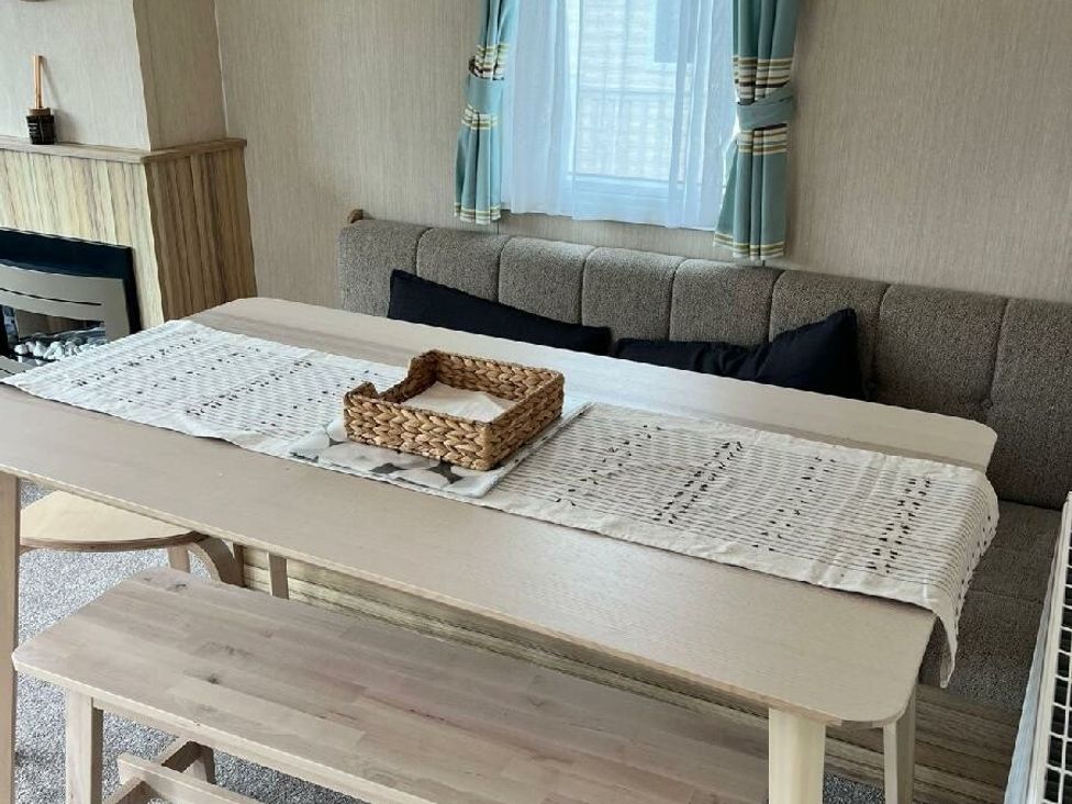 a dining area with a table and a sofa at Hoburne Devon Bay - Holiday Accommodation 22090 in Paignton