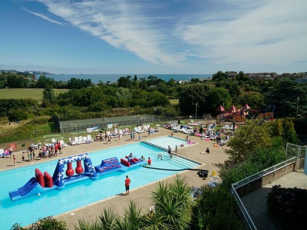a swimming pool with inflatable toys and people at Hoburne Devon Bay - Holiday Accommodation 22090 in Paignton