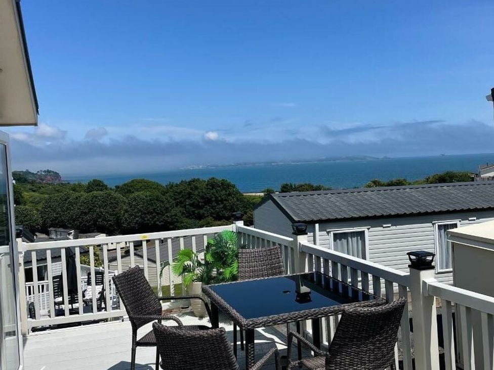 a balcony with a table and chairs overlooking the sea at Waterside, Paignton - Holiday Accommodation 22105, Paignton