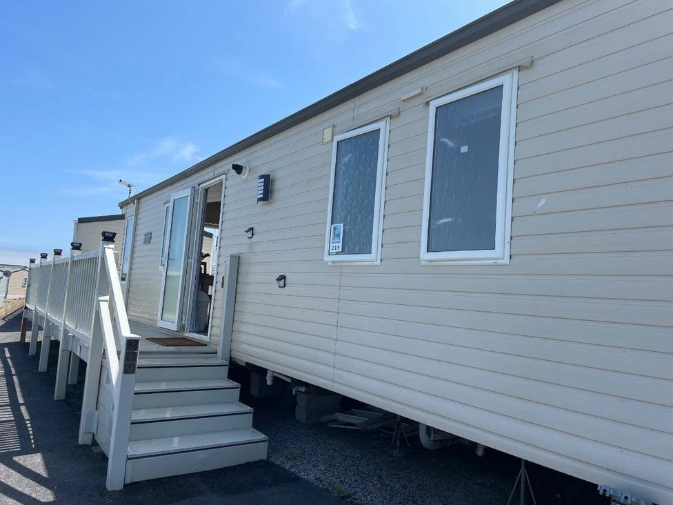 a static caravan with wooden steps and white siding at Waterside, Paignton - Holiday Accommodation 22105, Paignton