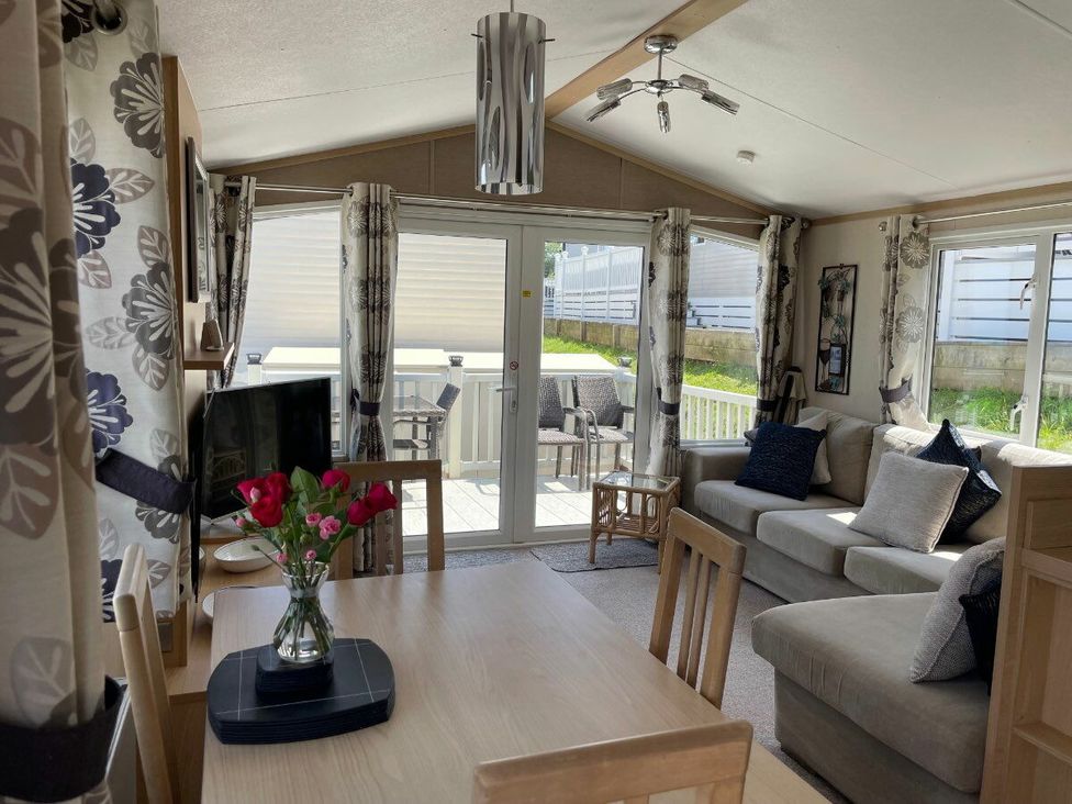 a living room with a sofa, dining table, and patio doors at Waterside, Paignton - Holiday Accommodation 22105, Paignton