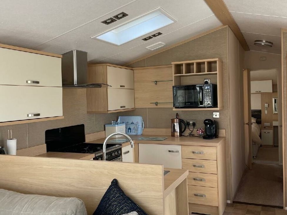 a kitchen area with wooden cabinets and appliances at Waterside, Paignton - Holiday Accommodation 22105, Paignton