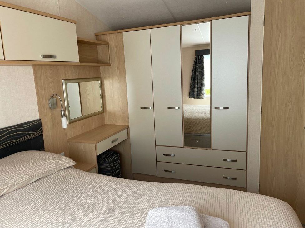 a bedroom with a bed, wardrobe, mirror, and desk at Waterside, Paignton - Holiday Accommodation 22105, Paignton
