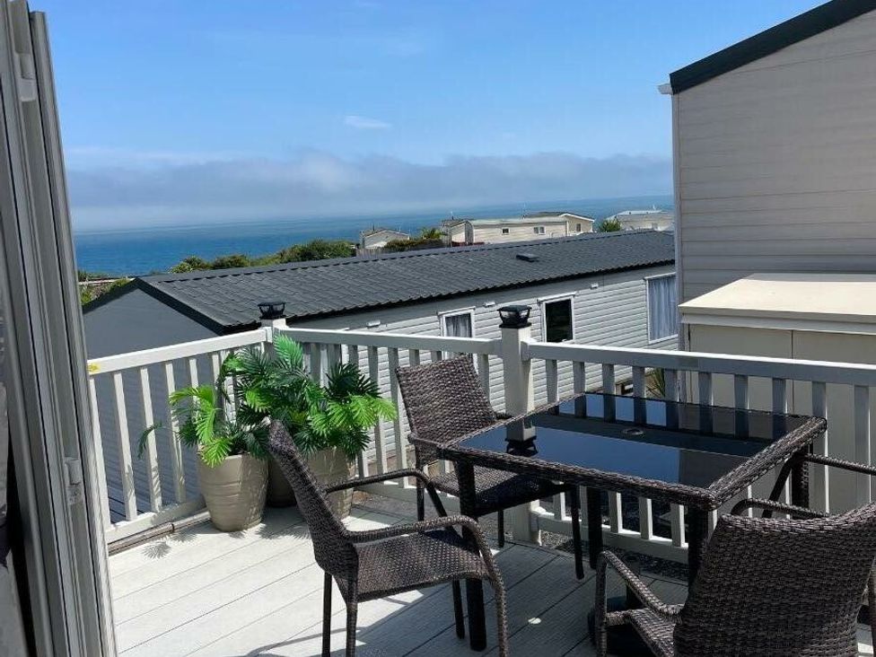 a balcony with a table and chairs overlooking the ocean at Waterside, Paignton - Holiday Accommodation 22105, Paignton