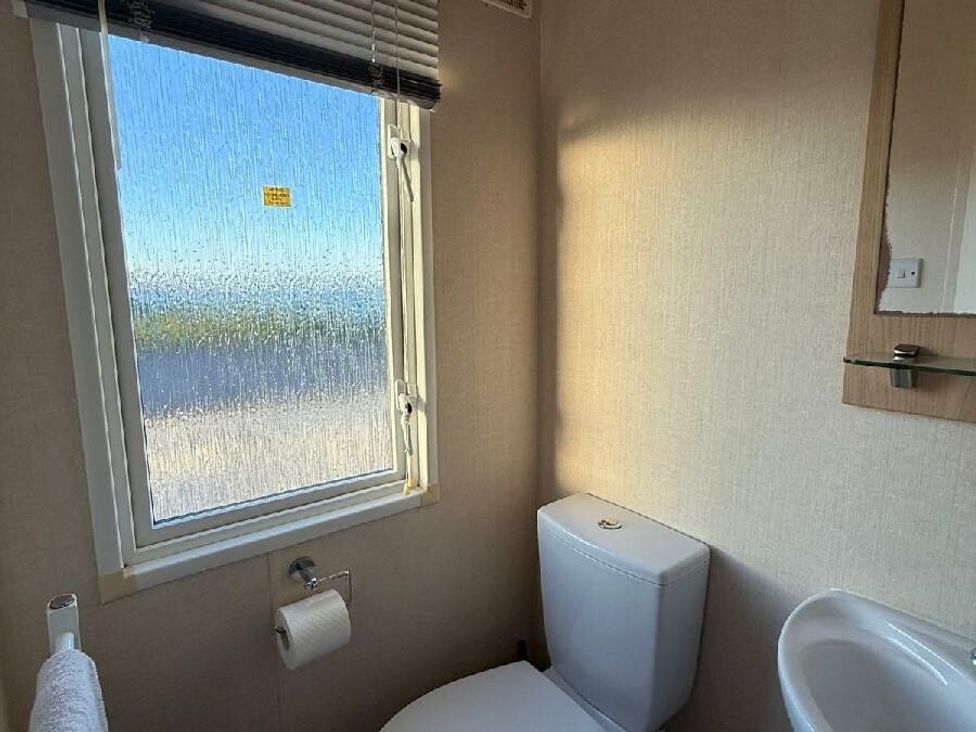 a bathroom with a toilet and sink, a window showing outdoor view at Waterside, Paignton - Holiday Accommodation 22105, Paignton
