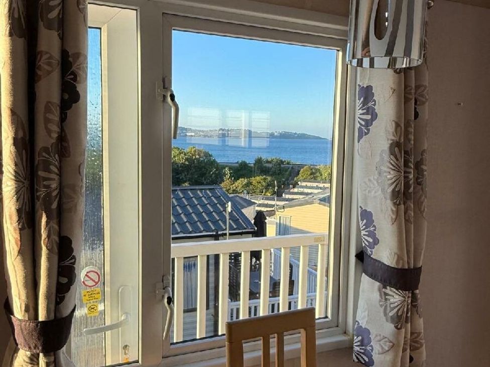 a view of the sea from a window with curtains at Waterside, Paignton - Holiday Accommodation 22105, Paignton