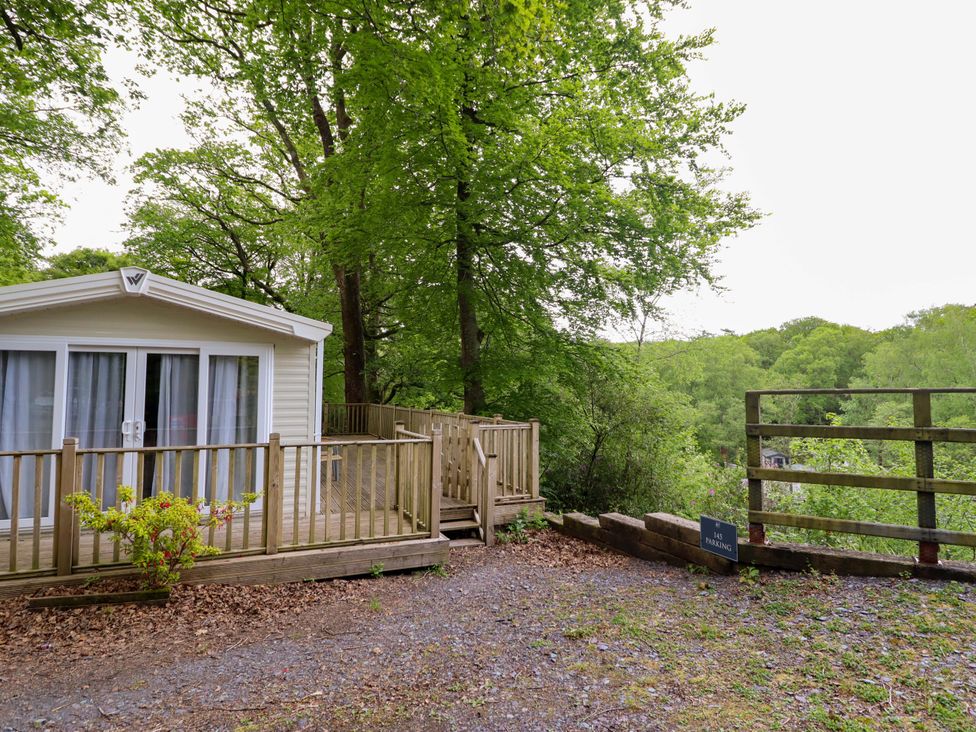 A cabin with a deck and steps at 145 Woodside View in Porthmadog