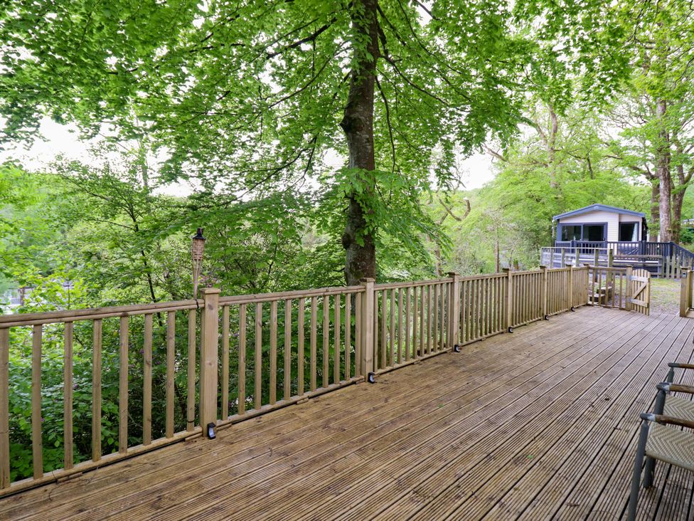 An outdoor deck with trees and a house at 145 Woodside View Porthmadog