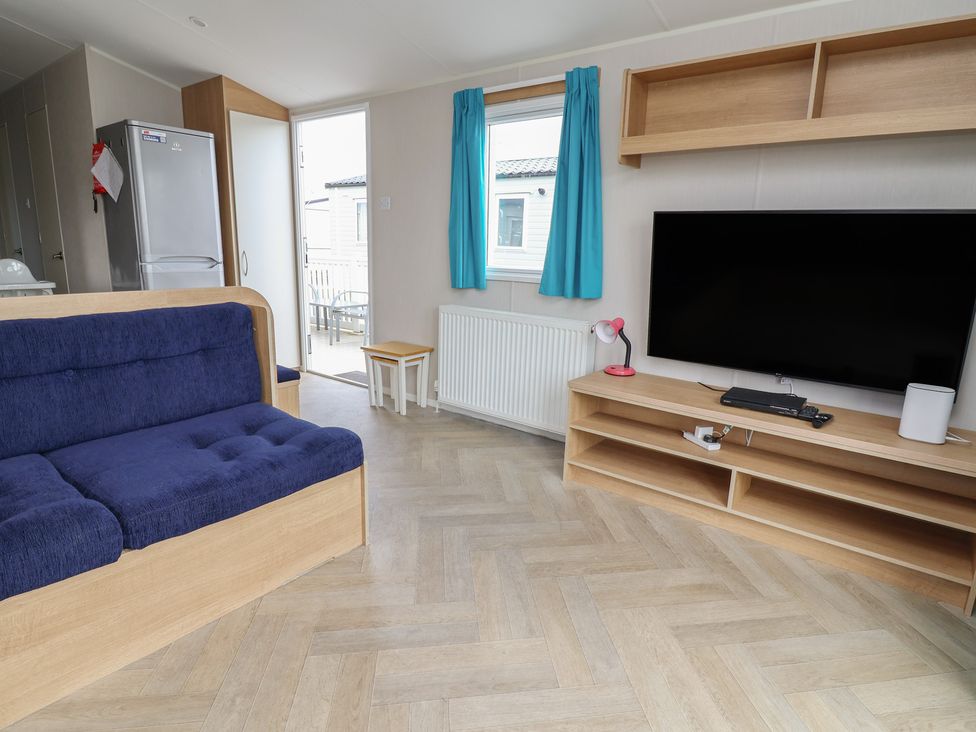 A living room with a sofa and television at Ty Mawr Holiday Park - Holiday Accommodation 22393 Towyn