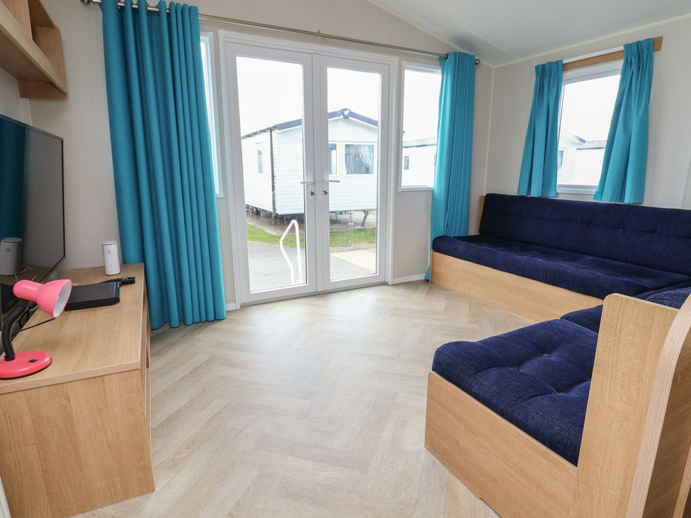 A living room with a sofa and television at Ty Mawr Holiday Park - Holiday Accommodation 22393 Towyn