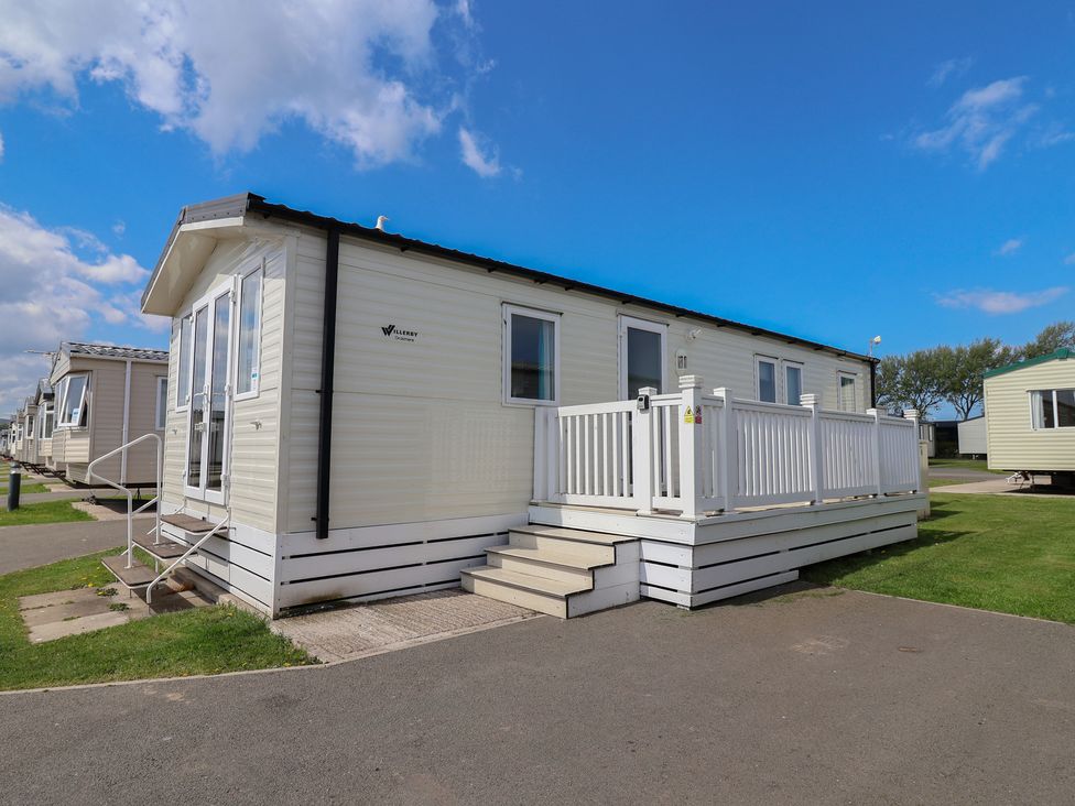 A caravan with a deck and stairs at Ty Mawr Holiday Park - Holiday Accommodation 22393 Towyn