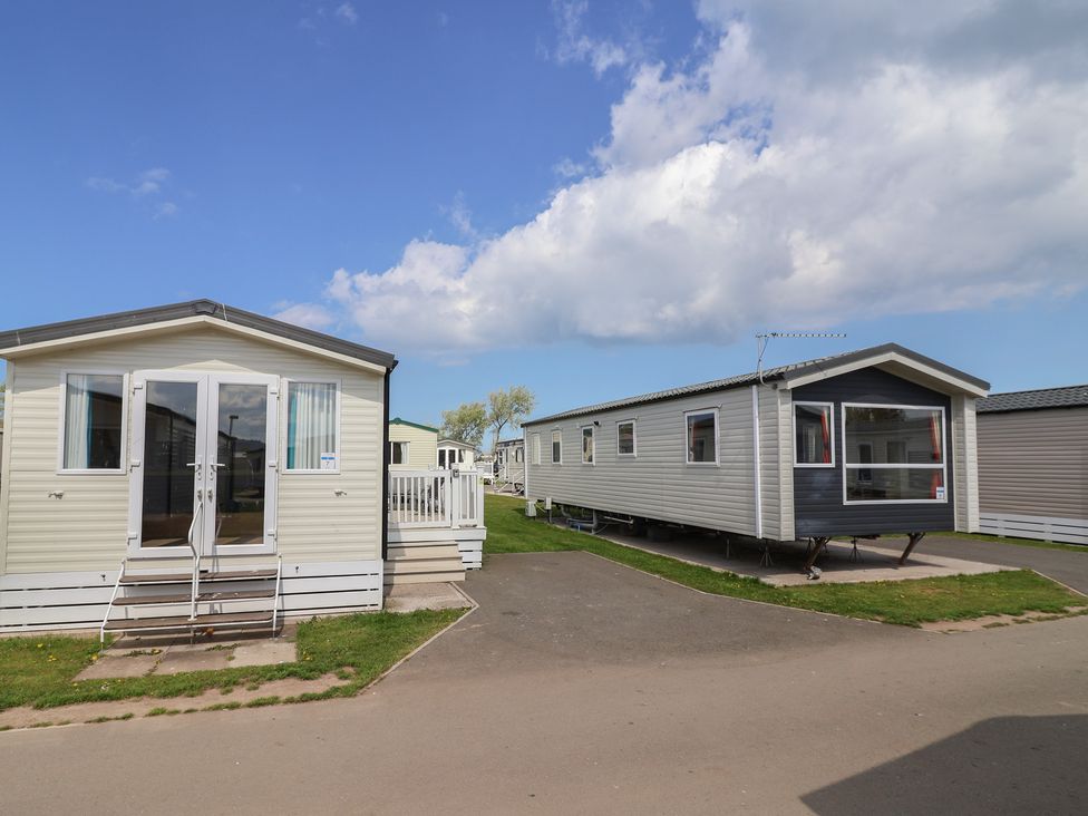 Mobile homes with a pathway between them at Ty Mawr Holiday Park - Holiday Accommodation 22393 Towyn